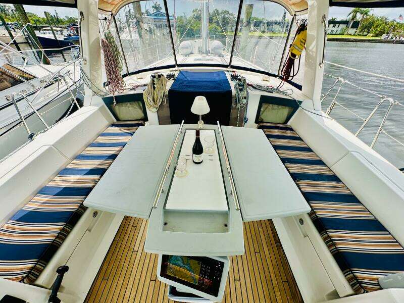 Cockpit of 2015 Beneteau Oceanis 45 with striped seating and table setup.