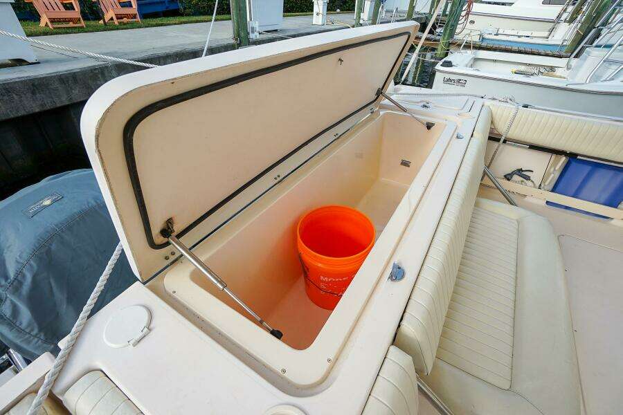 Open storage compartment on 2007 Grady-White Express 360 boat with orange bucket inside.