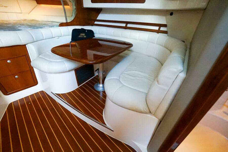 2007 Grady-White Express 360 interior with white leather seating and wooden table.