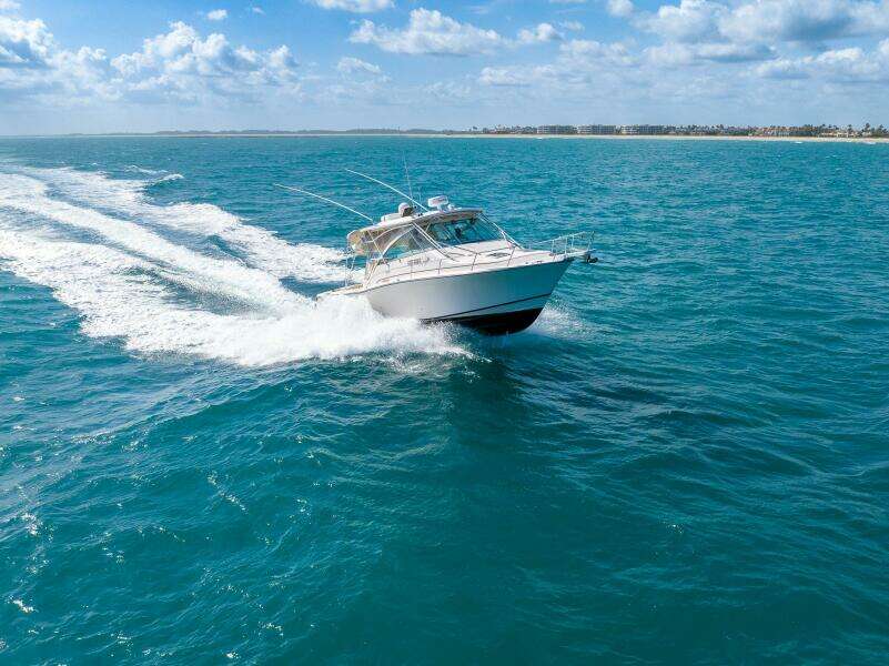 2007 Grady-White Express 360 cruising on clear blue ocean under a sunny sky.