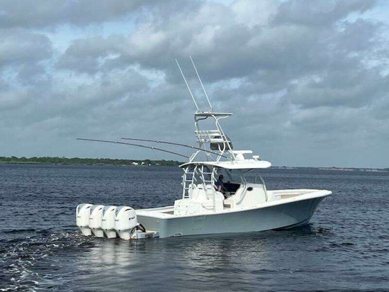 2018 Regulator 41 boat with four engines cruising on open water under cloudy skies.