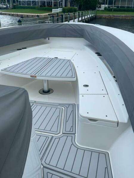 2018 Regulator 41 boat deck with seating and table, docked by the water.