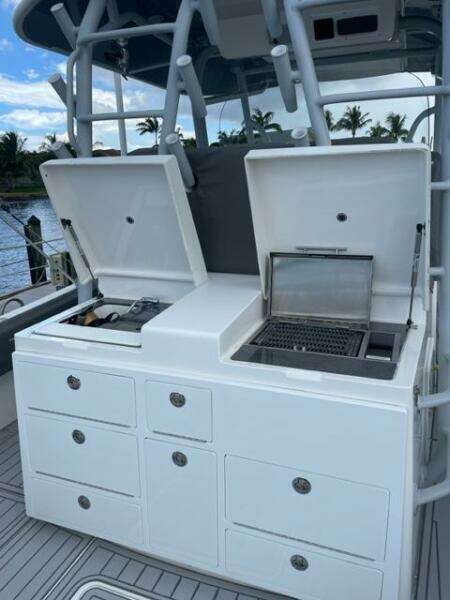 2018 Regulator 41 boat with open storage compartments and grill on deck.