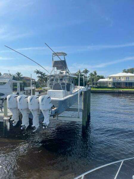 2018 Regulator 41 boat docked with four outboard engines, under a clear blue sky.
