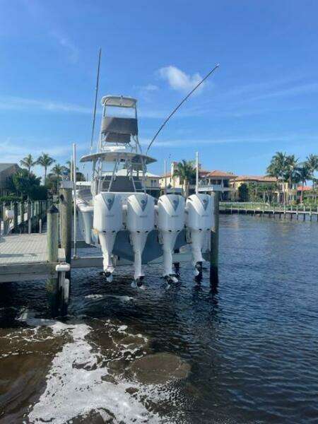 2018 Regulator 41 boat with four engines docked by waterfront homes.