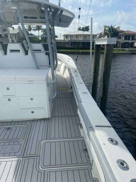 2018 Regulator 41 boat docked by waterfront homes, featuring spacious deck and modern design.