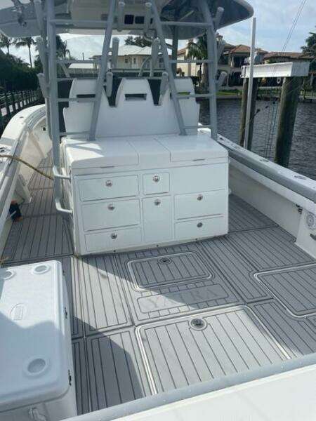 2018 Regulator 41 boat deck with storage compartments and seating, docked by waterfront homes.