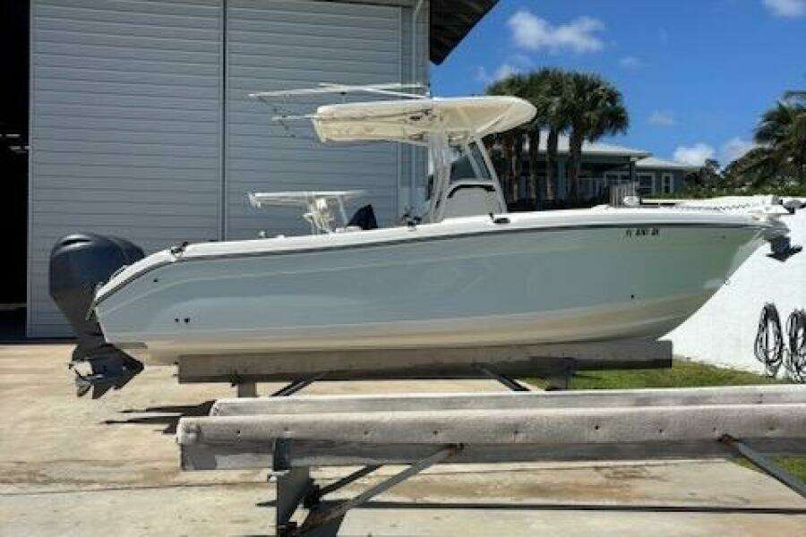 2018 Century 2600 Center Console boat on trailer, parked outdoors near a building.