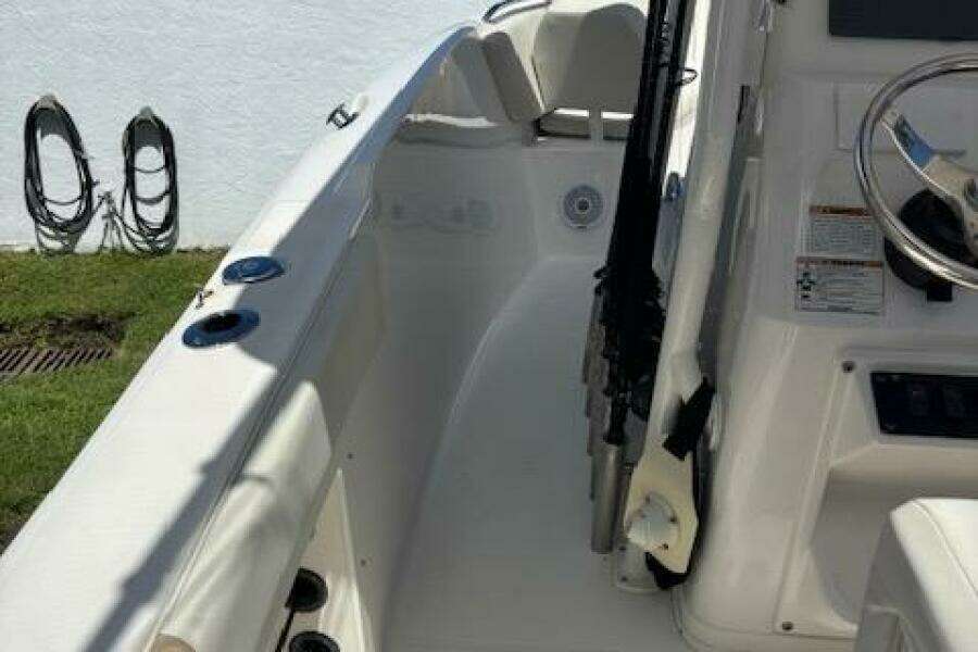 2018 Century 2600 Center Console boat interior with steering wheel and rod holders.