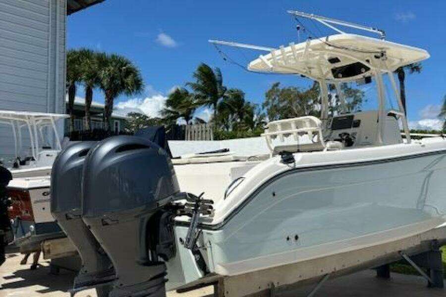 2018 Century 2600 Center Console boat with dual outboard motors, docked under a clear blue sky.