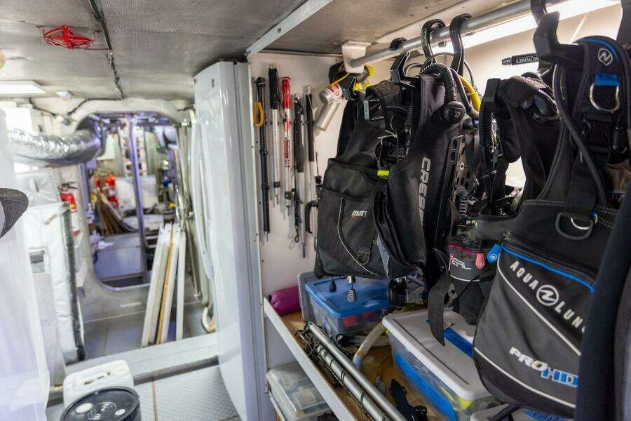 Diving equipment storage inside 1996 ABD 90 Explorer yacht, featuring organized gear and tools.