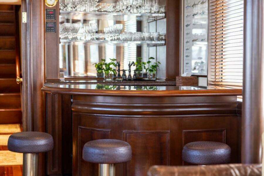 Luxurious dining area in 1996 ABD 90 Explorer yacht with TV and elegant decor.