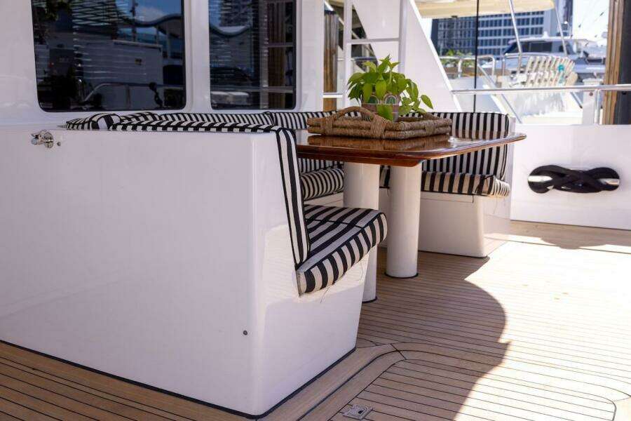 Luxury yacht deck with striped seating and wooden table, ABD 90 Explorer, 1996 model.