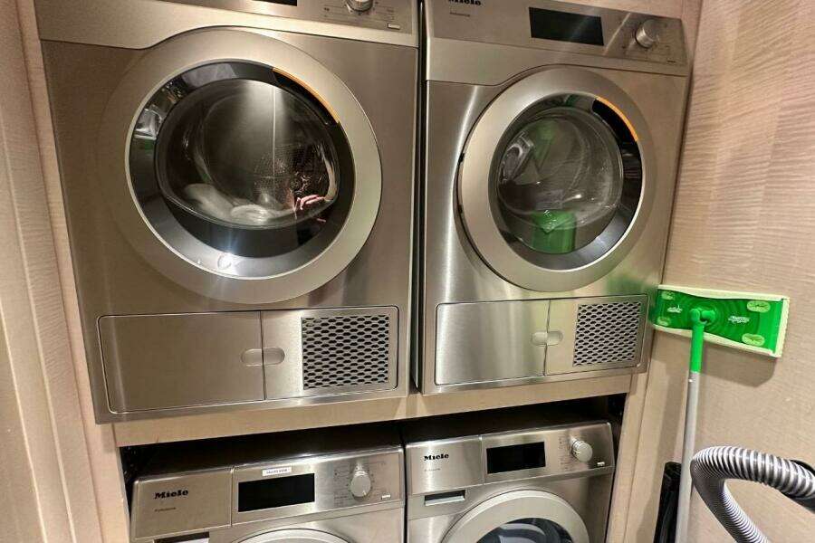 Stacked Miele laundry machines in a compact space, featuring a 2024 Majesty 120 model.