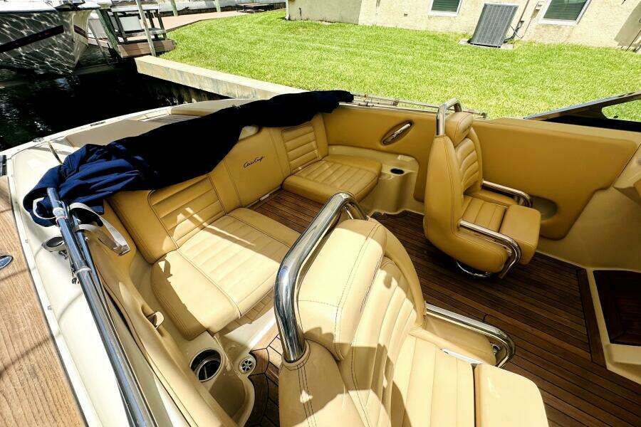 2013 Chris-Craft Corsair 22 boat interior with tan leather seats and wooden flooring.