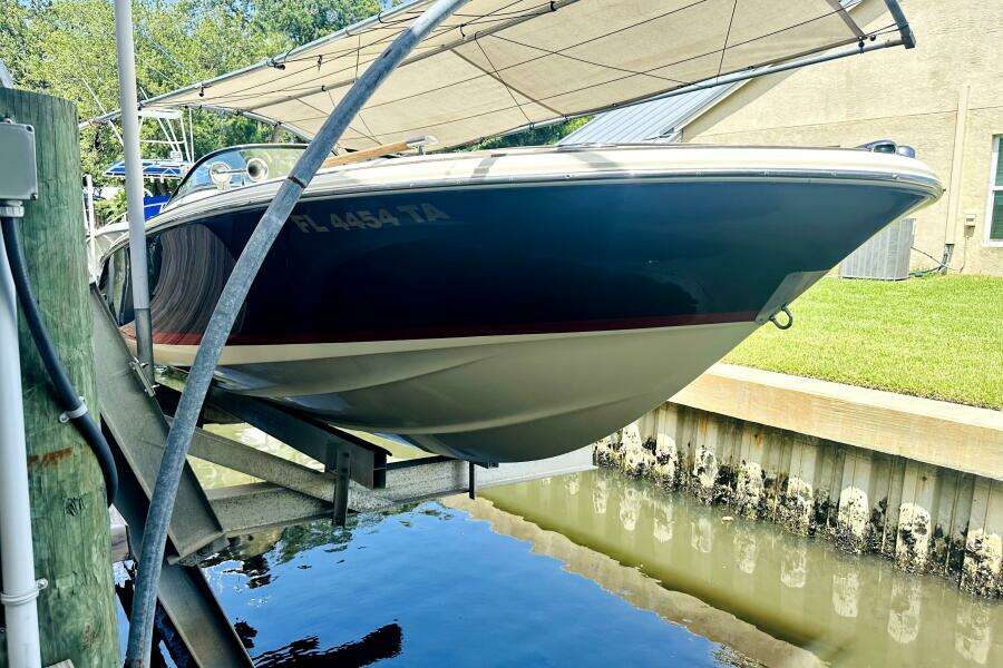 2013 Chris-Craft Corsair 22 boat docked, partially covered, with registration FL 4454 TA.