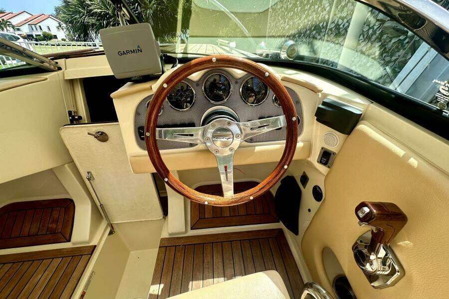 Interior of 2013 Chris-Craft Corsair 22 boat with wooden steering wheel and Garmin navigation.