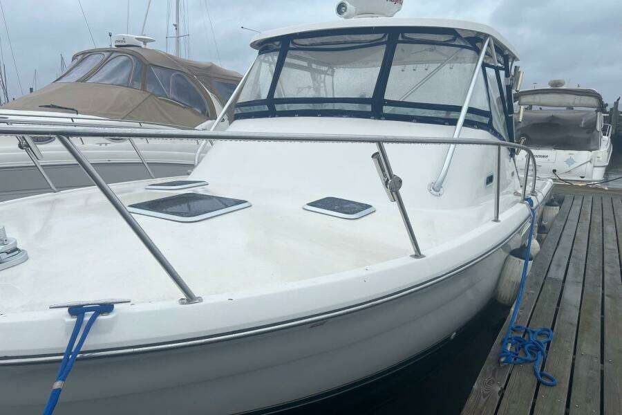2001 Pursuit 3000 Offshore boat docked at marina, featuring sleek design and spacious deck.
