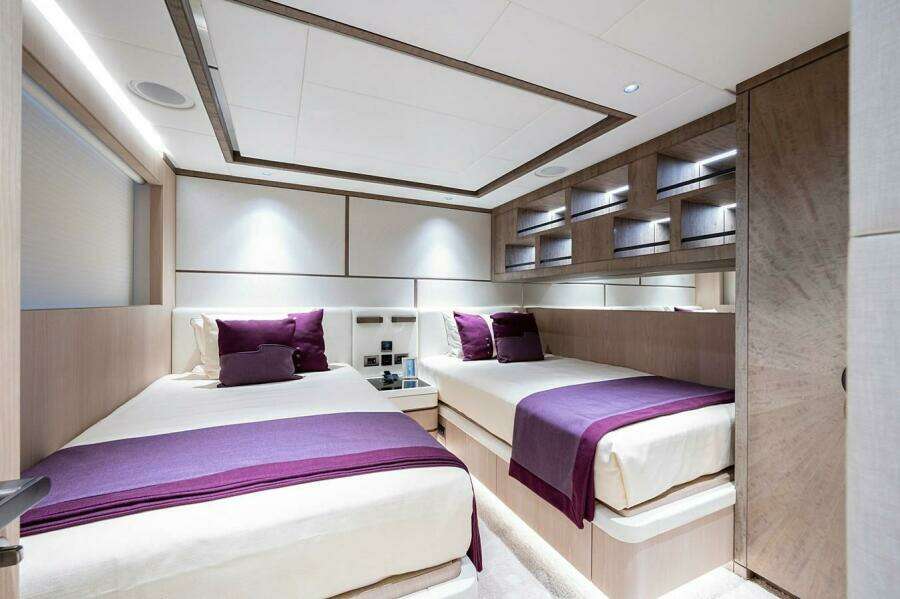 Luxurious twin bedroom on 2020 Majesty 140 yacht with modern decor and purple accents.