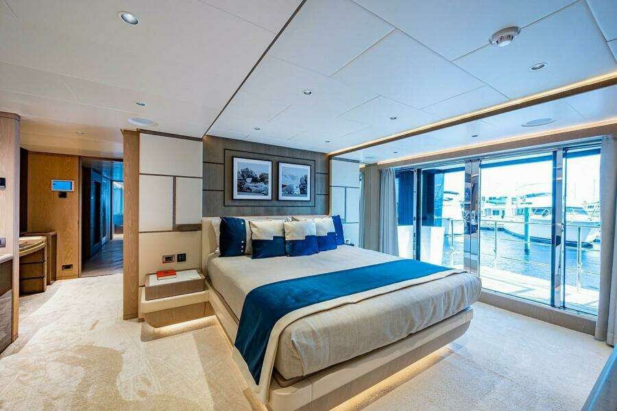 Luxurious bedroom on 2020 Majesty 140 yacht with modern decor and marina view.