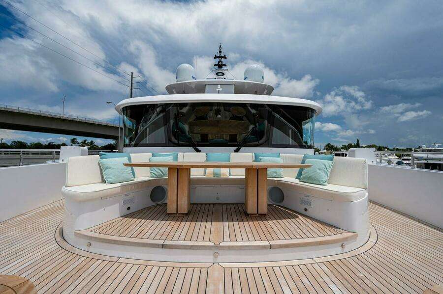 Luxurious 2020 Majesty 140 yacht deck with seating and table under cloudy sky.