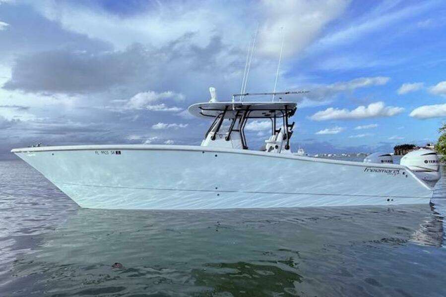 2019 Freeman 34 boat on calm water under a partly cloudy sky.