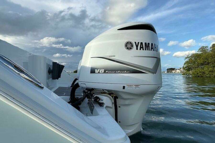 Yamaha V8 outboard motor on a 2019 Freeman 34 boat, set against a scenic water backdrop.