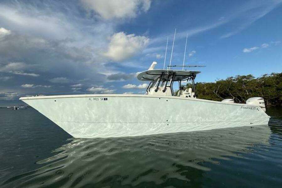 2019 Freeman 34 boat on calm water under a partly cloudy sky.