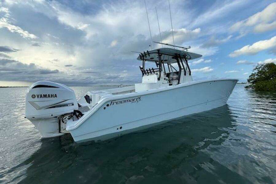 2019 Freeman 34 boat with Yamaha engine on calm water under cloudy sky.