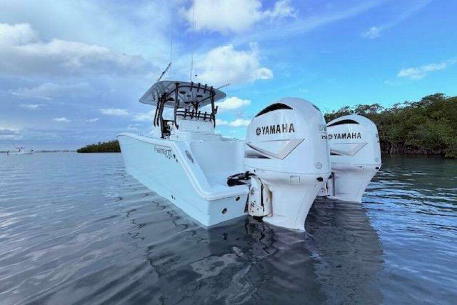 2019 Freeman 34 boat with twin Yamaha engines on calm water.