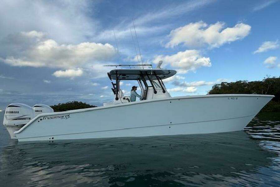 2019 Freeman 34 boat on water with Yamaha engines, under a partly cloudy sky.