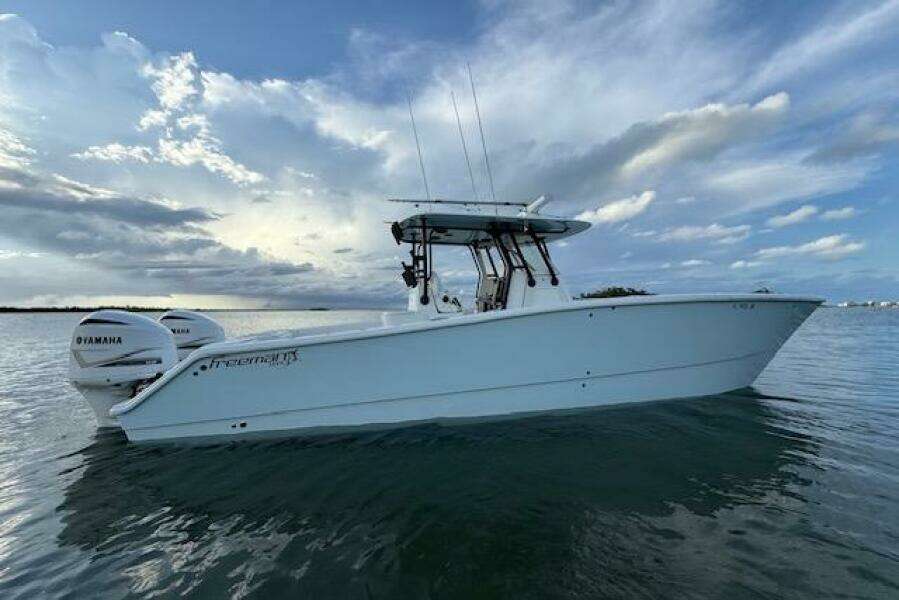 2019 Freeman 34 boat on calm water under a cloudy sky.