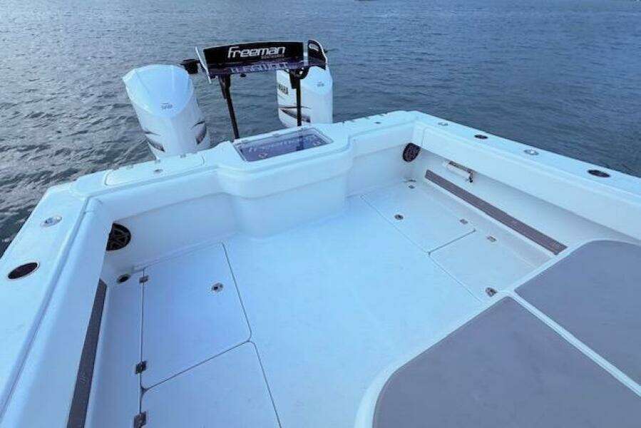 2019 Freeman 34 boat deck with twin engines on calm water.