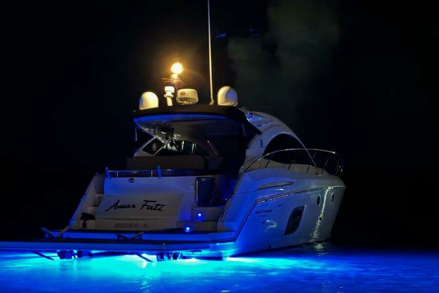 2014 Beneteau Gran Turismo 44 yacht illuminated at night with blue underwater lights.