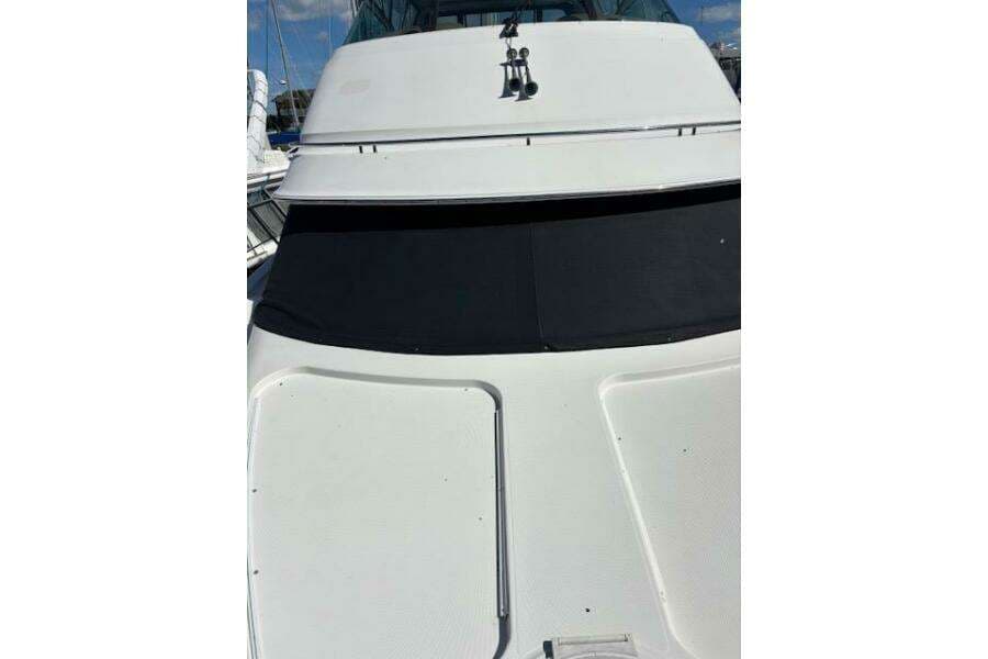 2004 Carver 466 Motor Yacht with sleek white exterior and tinted windows.