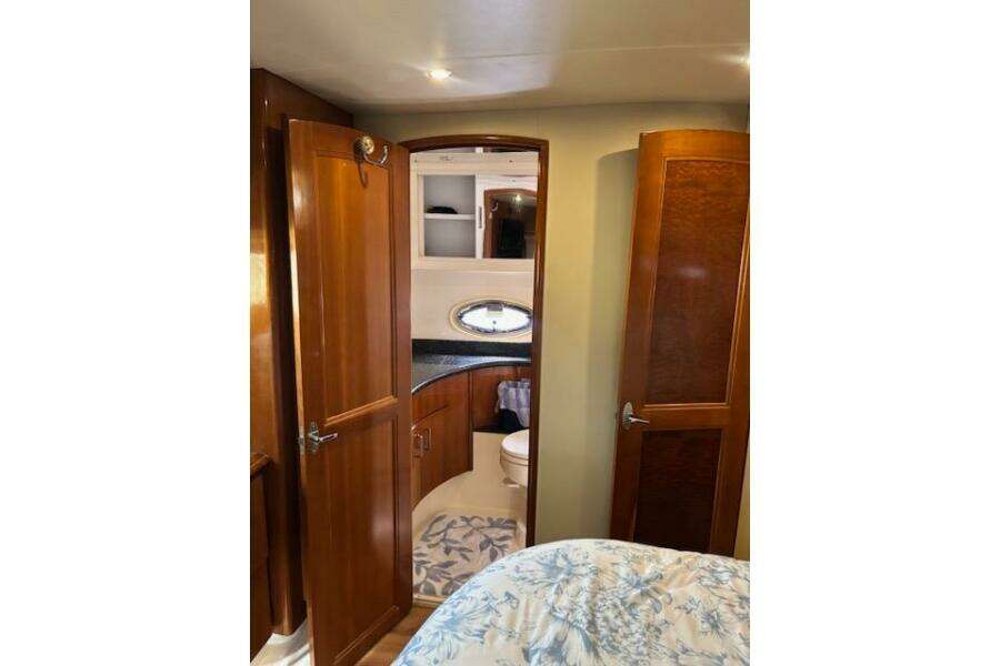 Interior of 2004 Carver 466 Motor Yacht with wooden cabinetry and bathroom view.