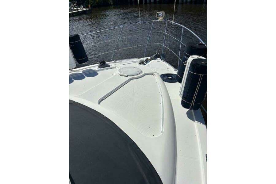 2004 Carver 466 Motor Yacht deck with railing and fenders on a sunny day.