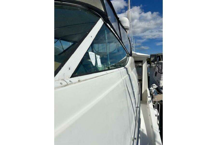 2004 Carver 466 Motor Yacht side view with clear skies and marina background.
