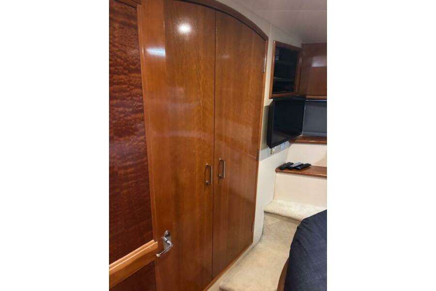 2004 Carver 466 Motor Yacht interior with wooden cabinets and a mounted TV.