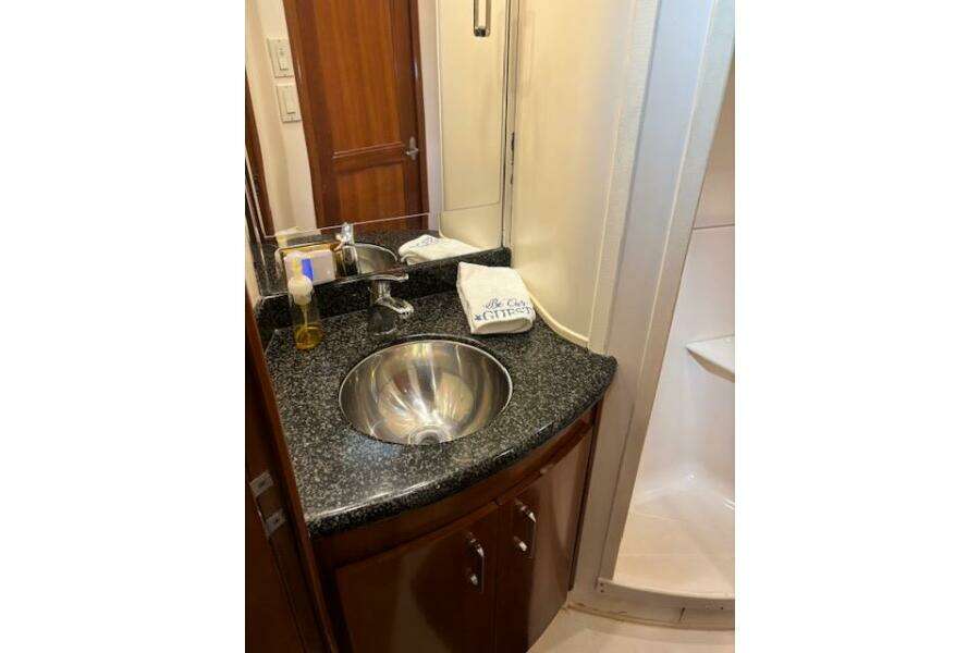 Luxurious bathroom in 2004 Carver 466 Motor Yacht with granite countertop and stainless steel sink.
