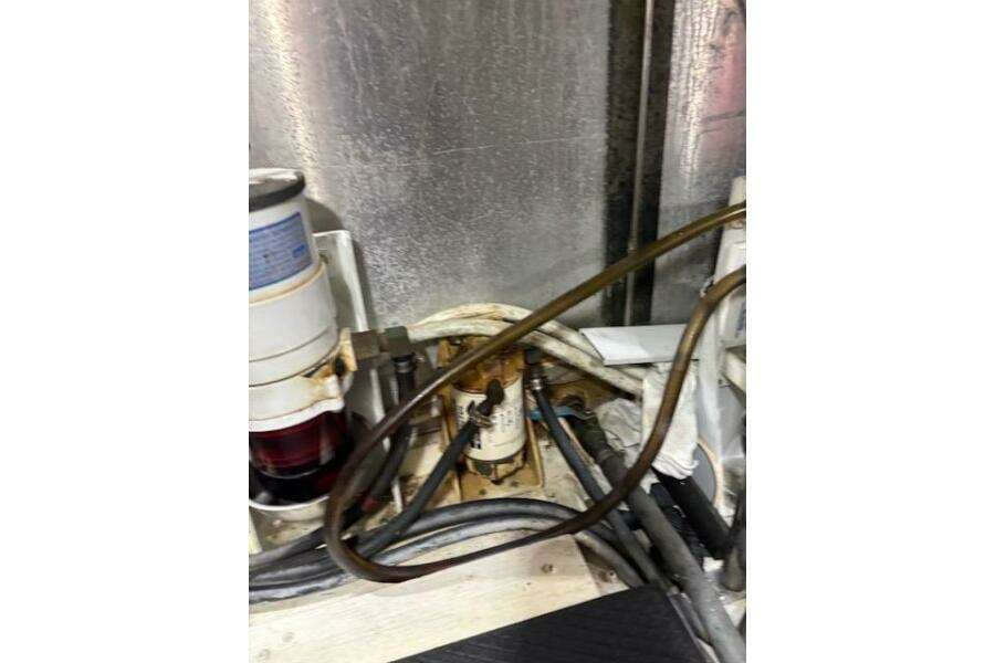 Engine room of 2004 Carver 466 Motor Yacht with visible fuel filter and hoses.