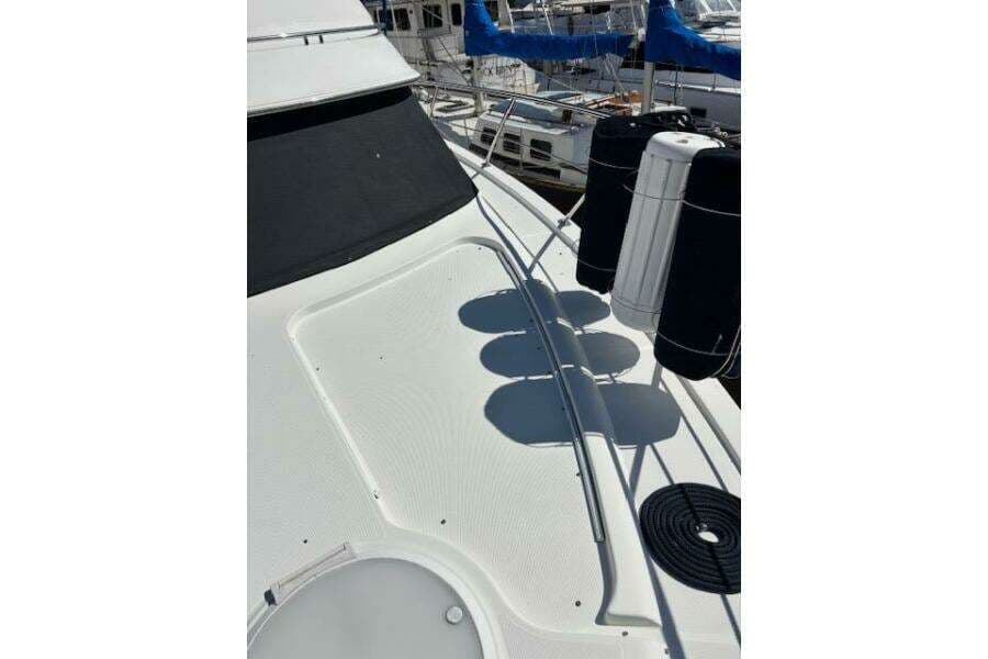 2004 Carver 466 Motor Yacht deck with fenders and railing in marina.