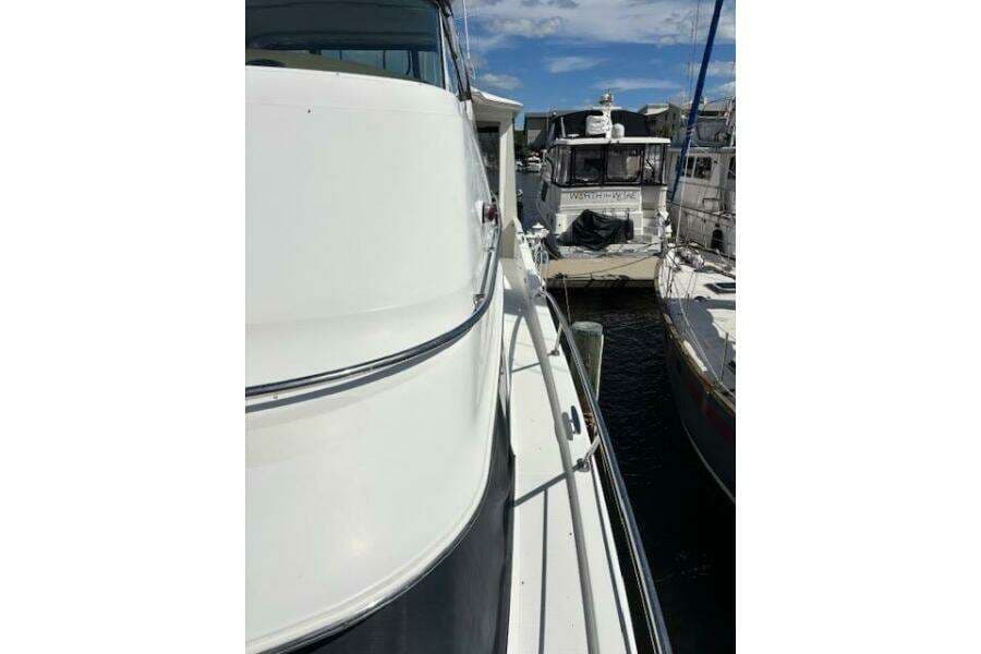 2004 Carver 466 Motor Yacht docked at marina, side view with clear sky.