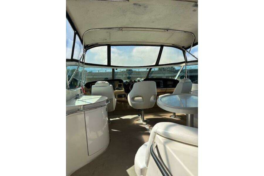 2004 Carver 466 Motor Yacht interior with helm, seating, and panoramic windows.