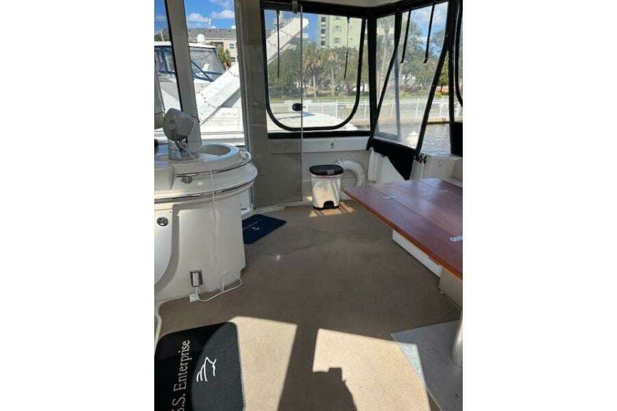 Interior of 2004 Carver 466 Motor Yacht with seating and windows, docked by water.