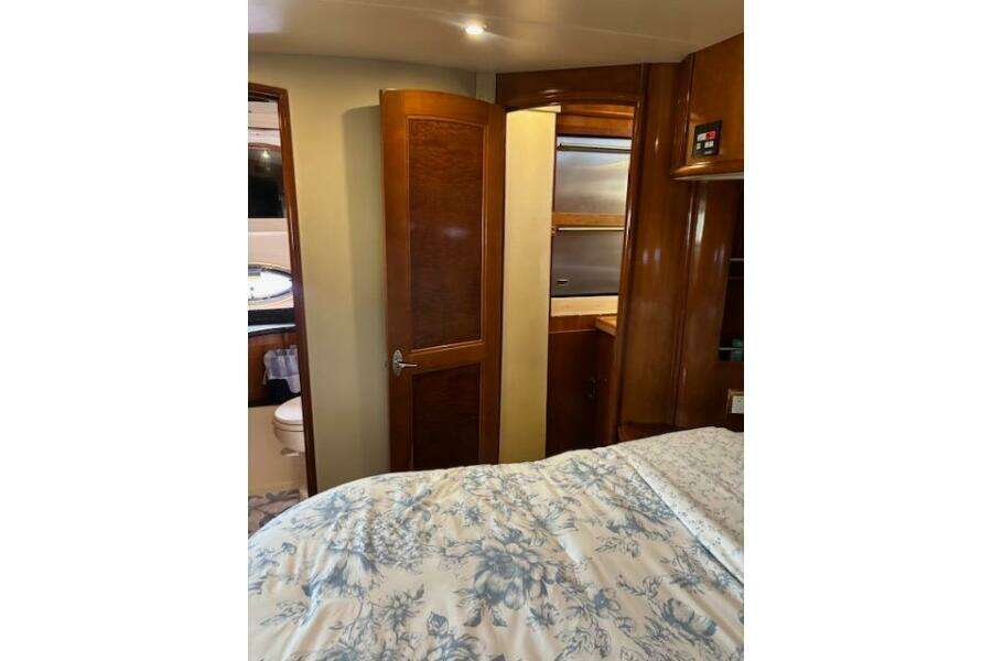 Interior of 2004 Carver 466 Motor Yacht bedroom with wooden cabinetry and floral bedding.