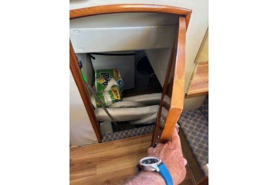 Storage compartment in 2004 Carver 466 Motor Yacht with cleaning supplies and equipment.