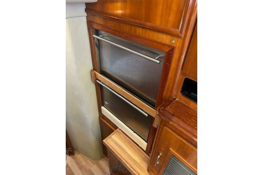 2004 Carver 466 Motor Yacht interior with stainless steel appliances and wooden cabinetry.