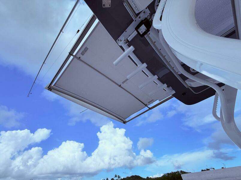 2024 Scout 400 LXF boat canopy against a bright blue sky with clouds.