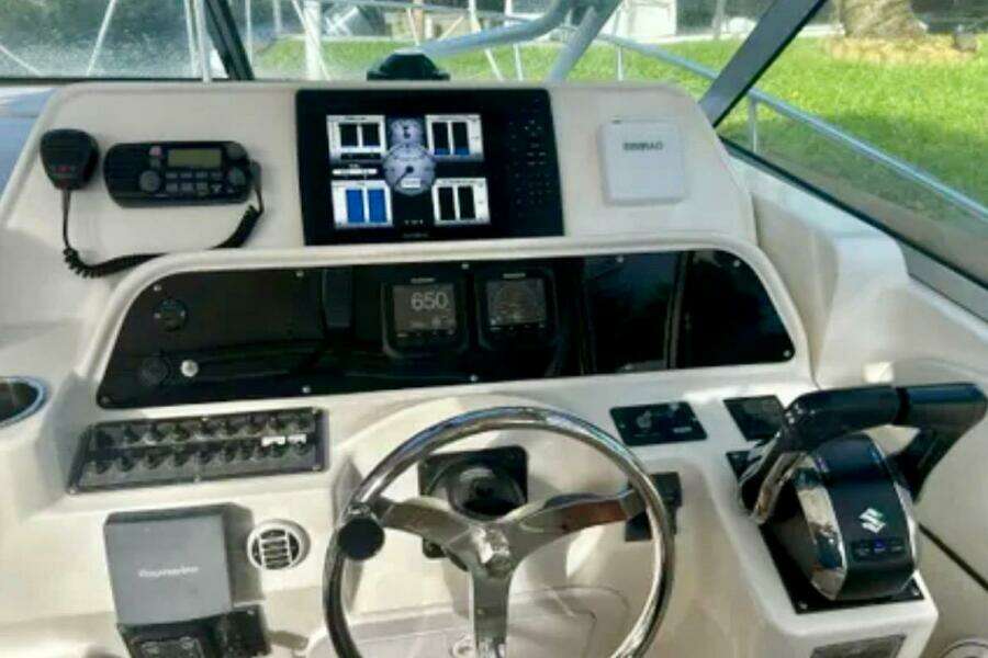 2002 Wellcraft 290 Coastal boat dashboard with steering wheel and navigation controls.